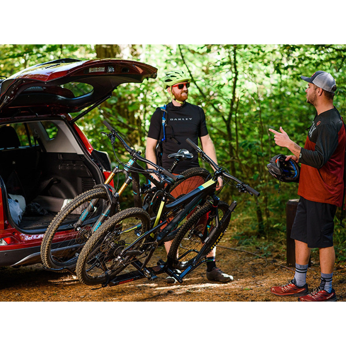 Riders chatting beside bikes tilted away from an open hatch