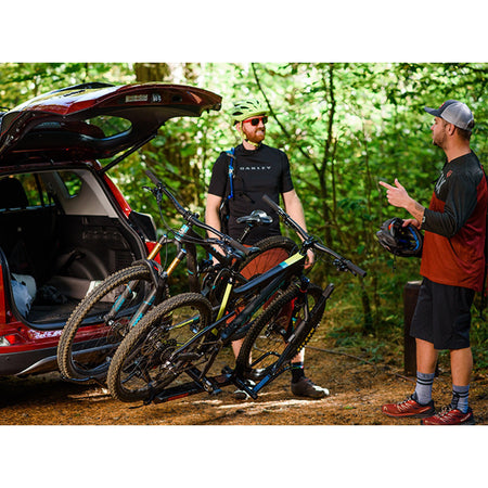 Riders chatting beside bikes tilted away from an open hatch