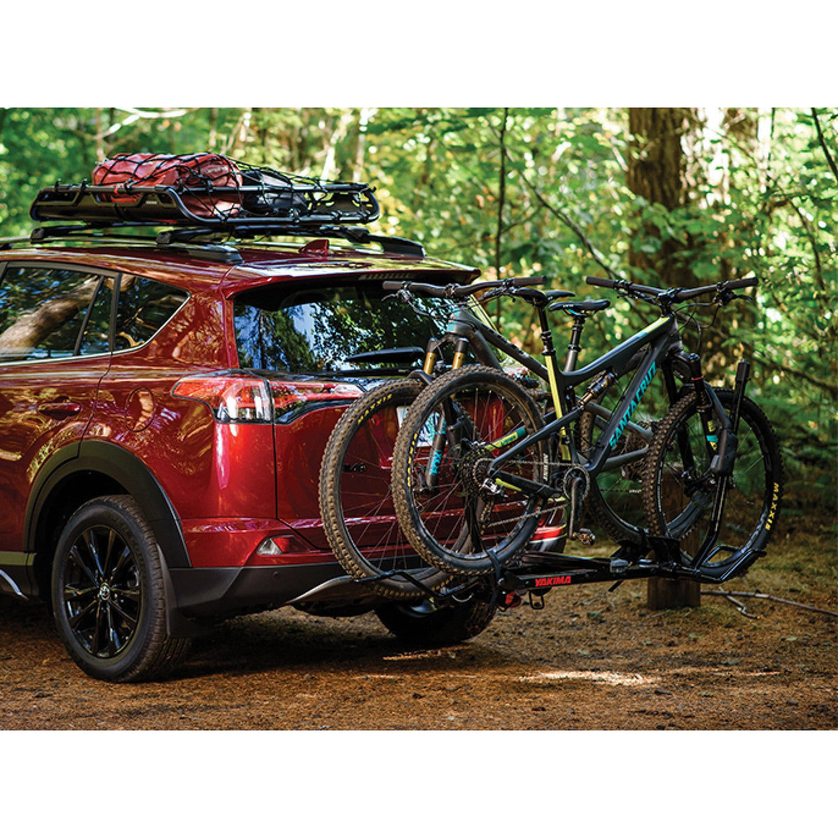 Red SUV with two bikes on the rack in the woods