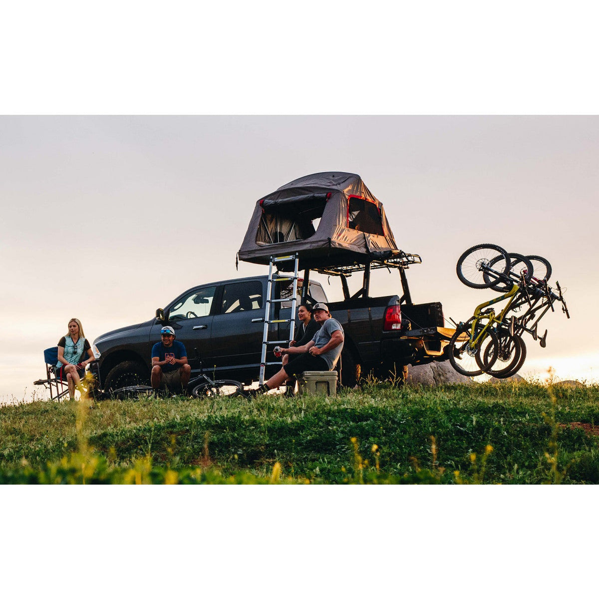 Camp setup with a rooftop tent and bikes on a vertical rack