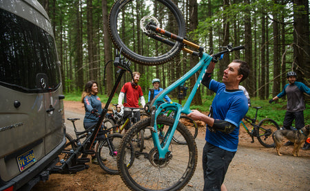 Rider lifting a mountain bike onto the vertical rack